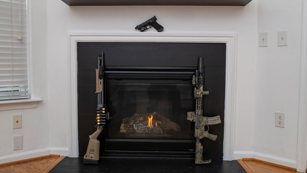 Home defense guns by a fireplace
