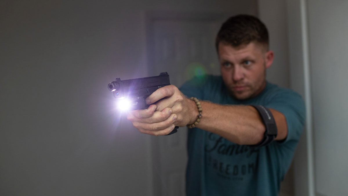 A man uses a Glock 17 pistol for home defense