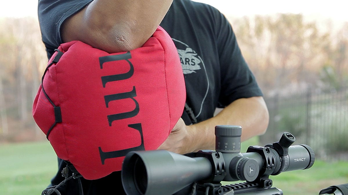 A large shooting bag supports a man's arm