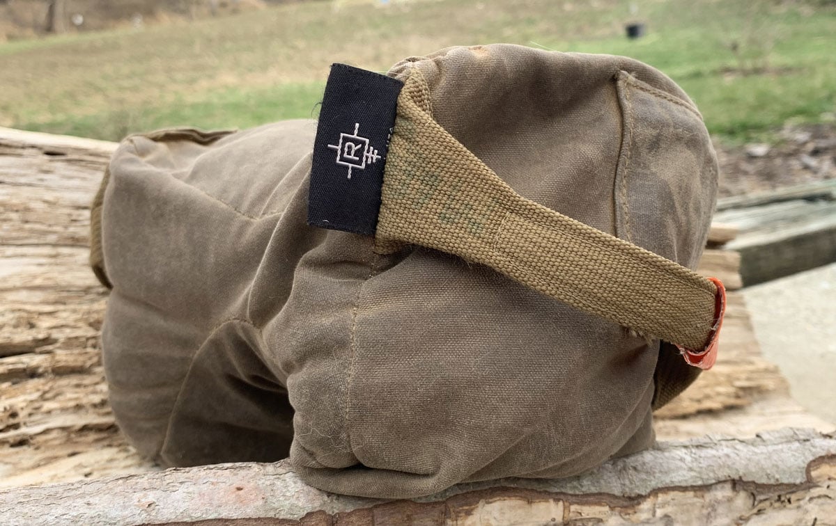 A shooting bag rests on a log