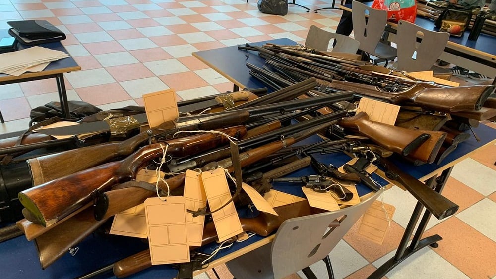 table of vintage guns turned in to French police