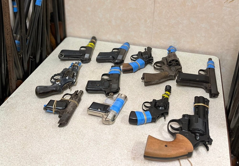 table of vintage guns turned in to French police