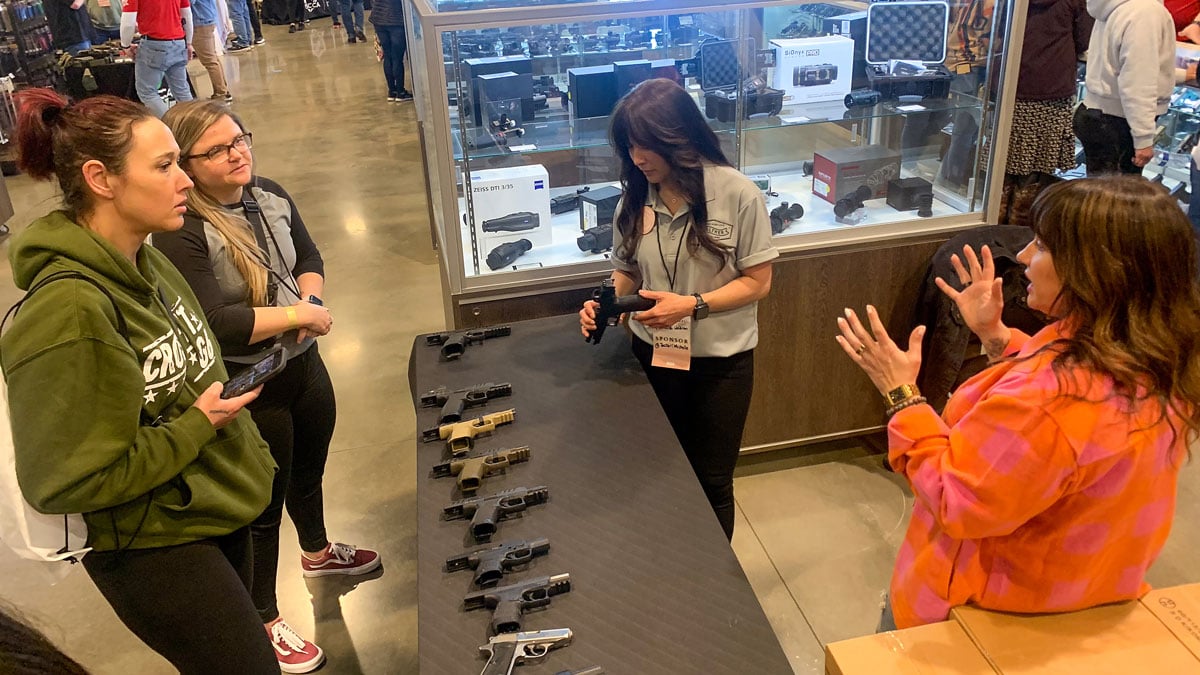 talking with women at Walther gun counter