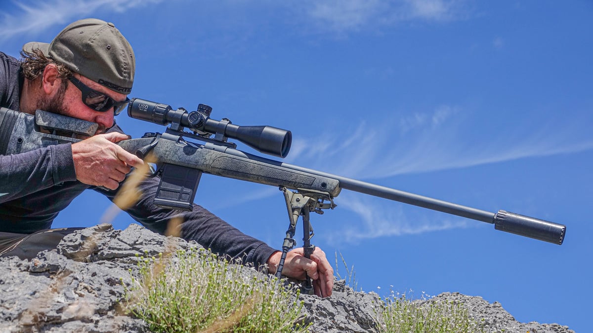aiming rifle in mountains