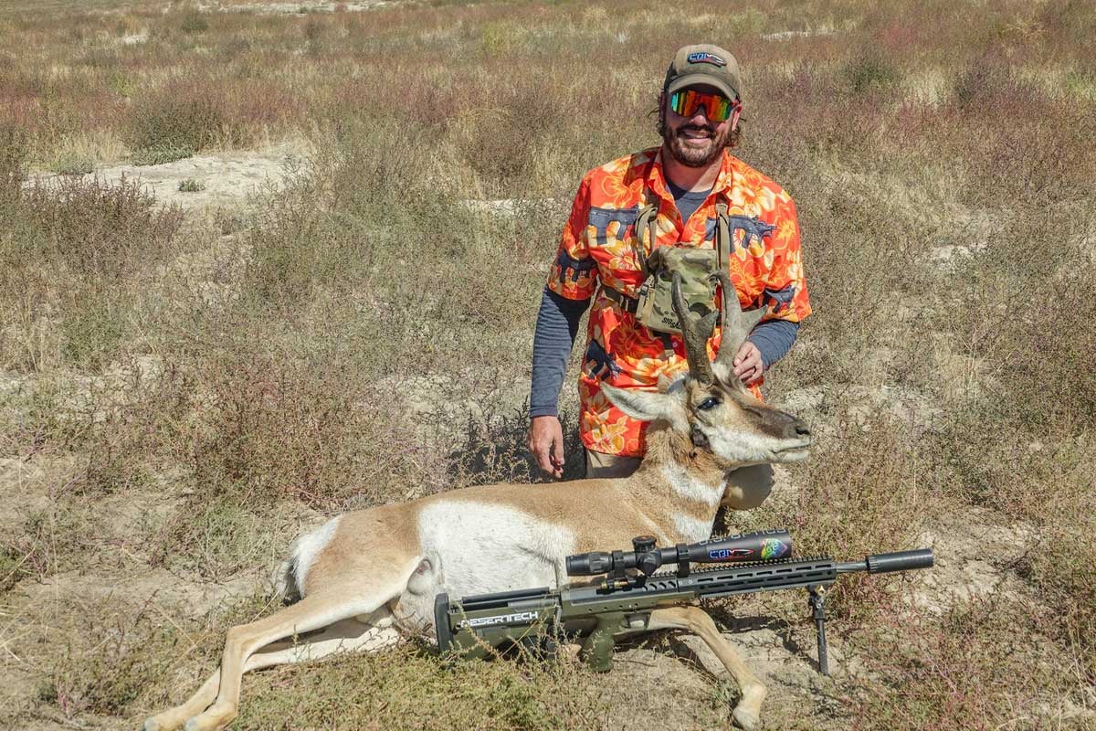 hunter with pronghorn and suppressed rifle