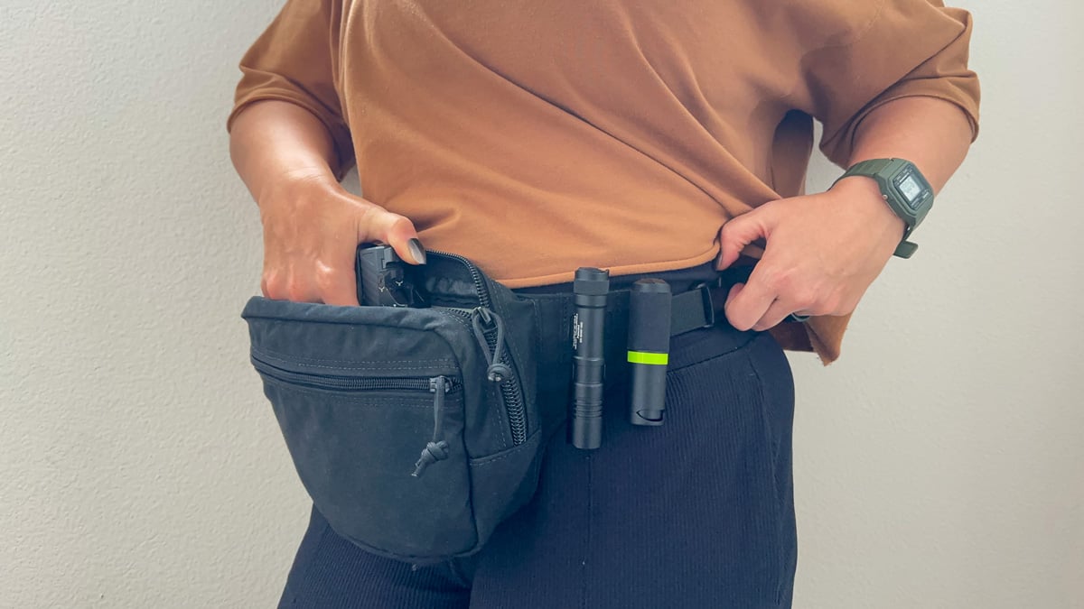 woman drawing gun from fanny pack