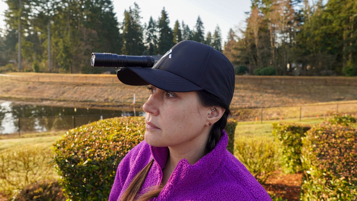 woman with tactical flashlight on hat brim