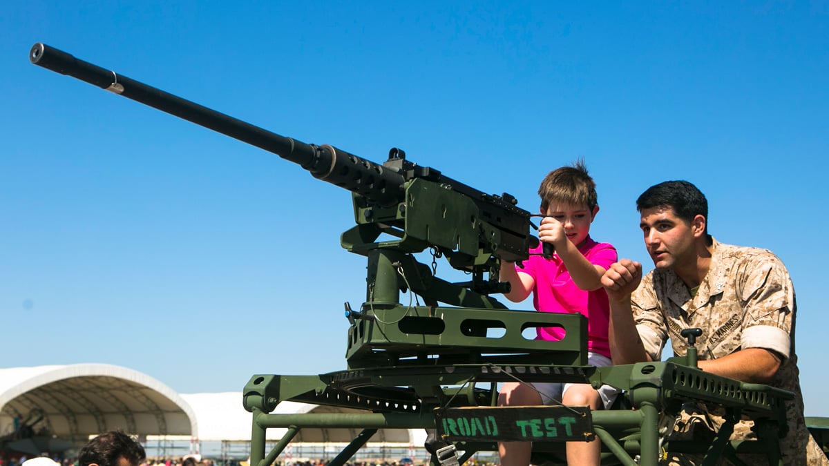 Marine instructs a youth on operating an M2A1 Browning