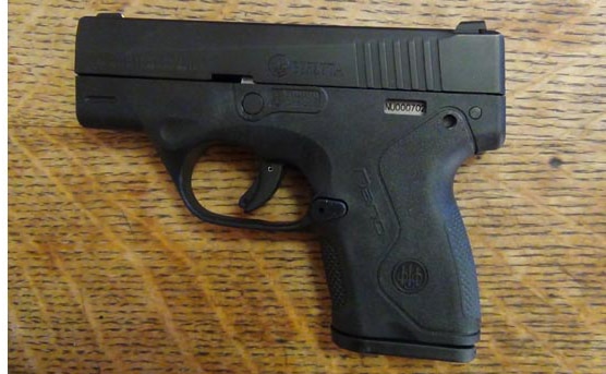 the beretta nano handgun sitting on a table indoors