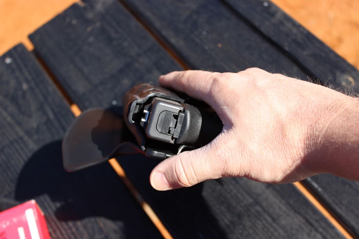 hand reaching for a handgun in the als holster