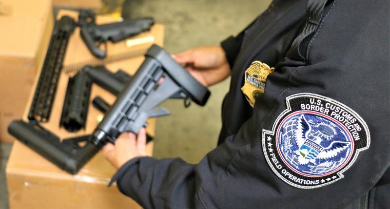 CBP officer holds gun parts