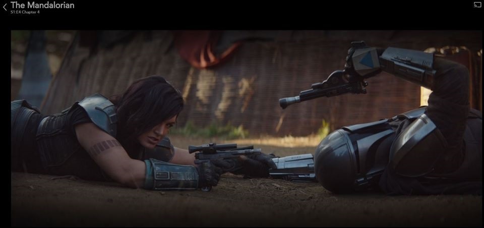 Cara and the Mandalorian draw their pistols after a brief scuffle in 