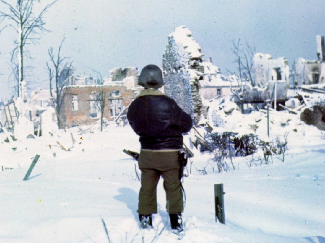 Wreckage in St. Vith, Belgium, after units of the 7th Armored Division, took the town, Jan 1945. Note the M1911 in the holster of the tank crewman (Photo: National Archives)